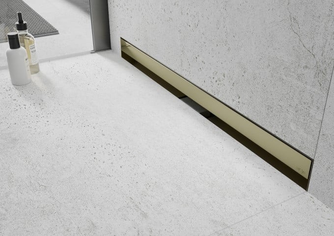 Złoty odpływ liniowy w betonowej łazience